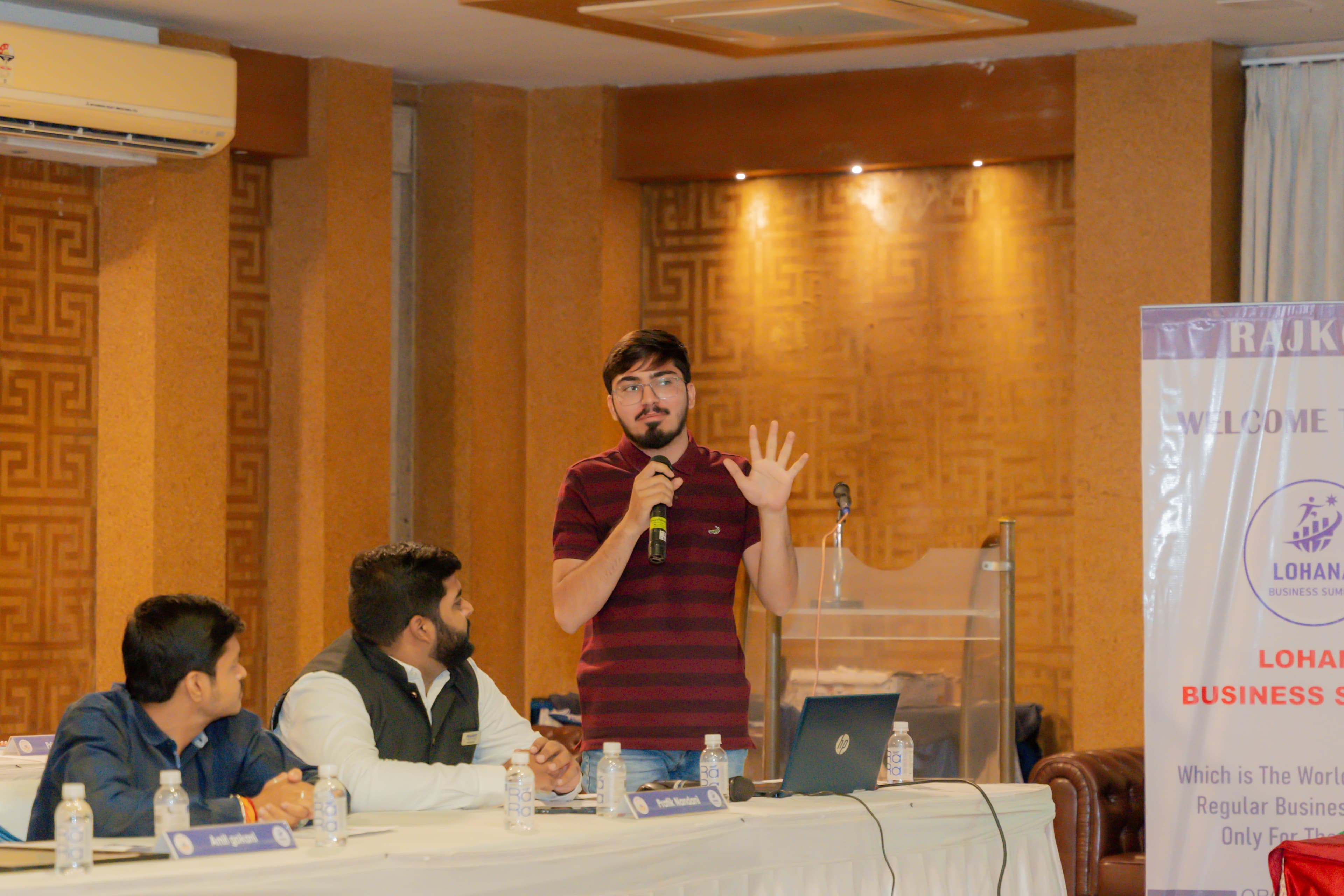 Utsav Somaiya speaking into a microphone at an event
