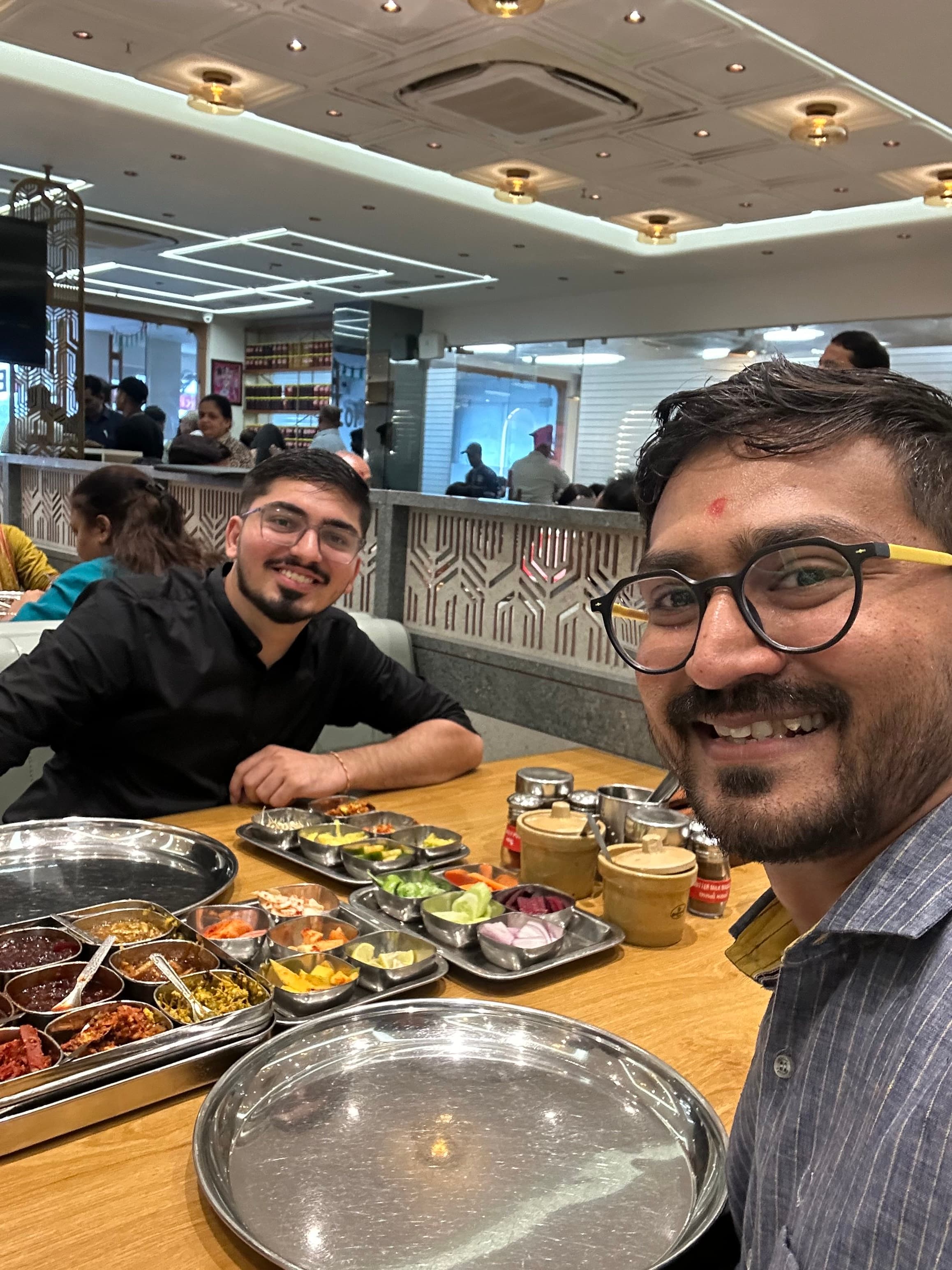 Utsav Somaiya sitting with a friend at dinner